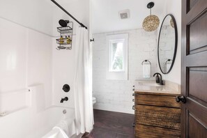Bathtub, hair dryer, towels, shampoo