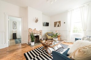 A living room with a fireplace, a sofa, a coffee table, and a TV.