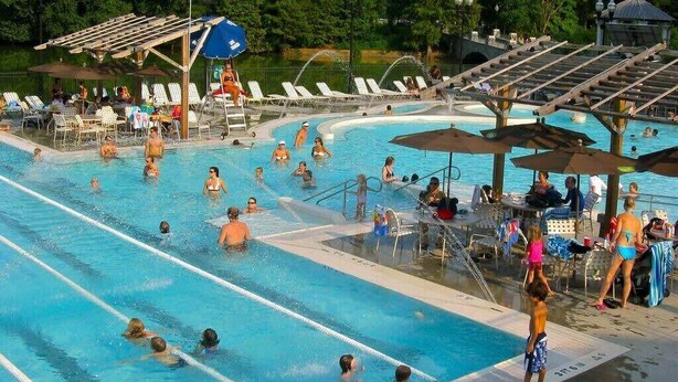 Une piscine avec plusieurs couloirs de nage, des chaises longues et des parasols.