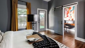 A modern bedroom with a bed, a desk, and a chair. - Whiskey Neat (Atlanta)