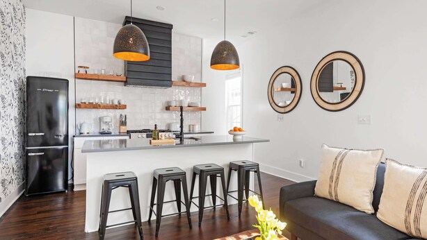 A modern kitchen with a central island, bar stools, and pendant lighting. - Whiskey Neat (Atlanta)