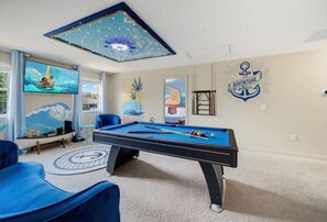 A room with a pool table, blue chairs, and a ceiling light fixture. - 6BR Family Friendly Resort Pool Home Near Disney (Davenport)