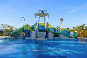 Un parque acuático con una piscina grande, toboganes y una estructura central.