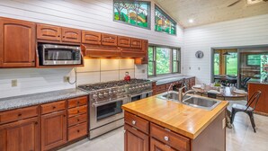 A spacious kitchen with wooden cabinets, a stainless steel stove, and a large island with a sink. - Private Mountain Home, 2miles To Ski, Hot Tub, Views, Fireplace, & Pet Friendly! (Beech Mountain)
