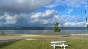 A picnic table and a lamppost by a lake with a rainbow. - Double Queen Room Sum (Lake City)