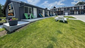 Een motel met buiten zitplaatsen en een picknicktafel.