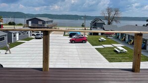 A view of a lakeside property with a covered deck, a pool, and several cabins. - Single King Room (Upper Level) (Lake City)