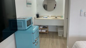 A bathroom with a sink, mirror, and a blue appliance, possibly a coffee maker, on the counter. - Single King Room (Upper Level) (Lake City)