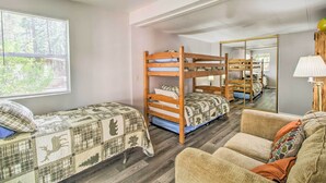 A dormitory room with bunk beds, a sofa, and a mirror reflecting the room. - 2 Mi to Rainbow Lake: Woodsy Retreat w/ Deck! (Lakeside)