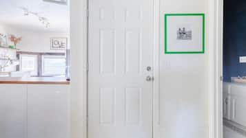 Uma porta branca com um quadro na parede à direita.