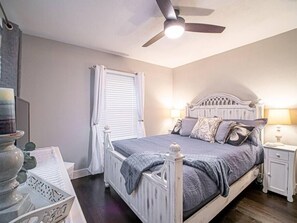 Cozy retreat with a single bed, bedside tables, and a ceiling fan.