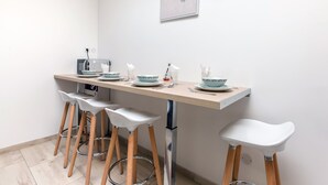 Eine moderne Küche mit einer Holzarbeitsplatte, weißen Barhocker und einem an der Wand befestigten Bild.