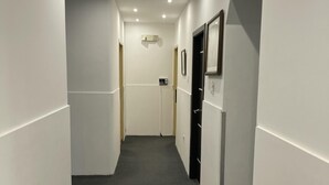 A narrow hallway with white walls, a dark carpet, and recessed ceiling lights. - ALSTON INN HOTEL (Quito)