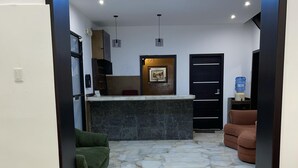 A modern kitchen with a marble countertop, a built-in oven, and a water dispenser. - ALSTON INN HOTEL (Quito)