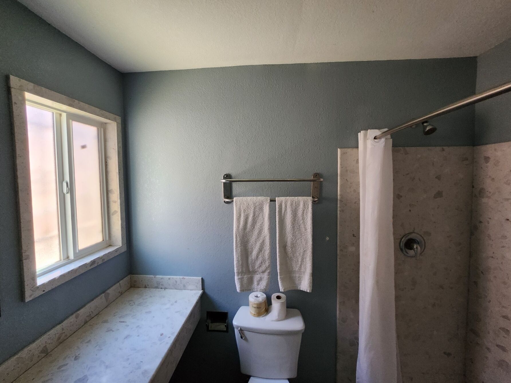 A bathroom with a bathtub, a toilet, and a window.