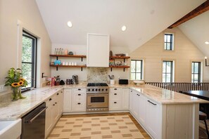 A kitchen with white cabinets, a central island, and a patterned floor.