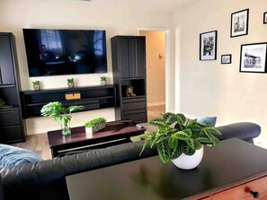 Relax in this stylish living room with a flat-screen TV, comfortable sofa, and decorative touches.