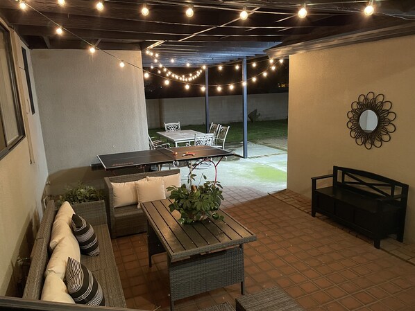 Enjoy meals or social gatherings in this outdoor patio area with a sofa and dining table.