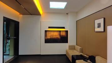 Una habitación de hotel con sofá, escritorio, silla, cama y ventana.