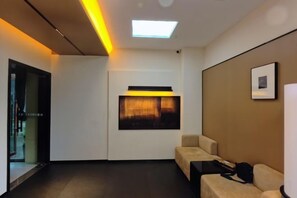 A hotel room with a sofa, a desk, a chair, a bed, and a window. - Mengfei Hotel (Liuzhou Yaobu Old Town) (Liuzhou)