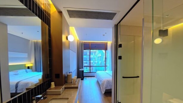 A hotel room with two beds, a bathroom, and a view of the city. - Mengfei Hotel (Liuzhou Yaobu Old Town) (Liuzhou)