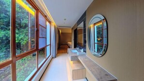 A hallway with large windows, a bench, and a mirror. - Mengfei Hotel (Liuzhou Yaobu Old Town) (Liuzhou)