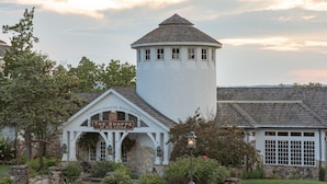 A building with a sign reading "The Shoppe at Big Cedar," featuring a stone facade, a tower with windows, and a garden area. - Feb 10th-17th - Beautiful Lodge, Scenic Views, Family Friendly (Ridgedale)