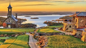 A church with a steeple, a stone building with a balcony, and a golf course with a path leading to the church. - Feb 10th-17th - Beautiful Lodge, Scenic Views, Family Friendly (Ridgedale)