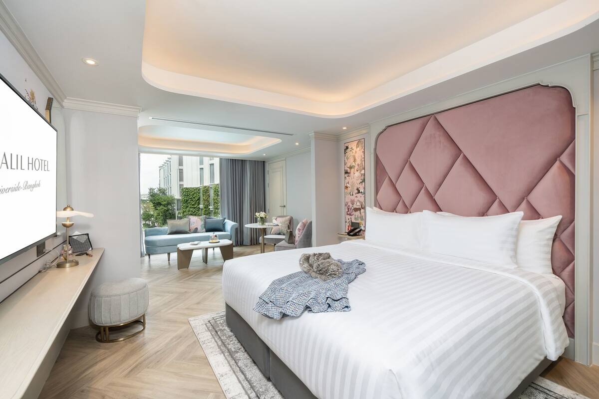 Een moderne hotelkamer met een groot bed, een bureau en uitzicht op de omgeving.