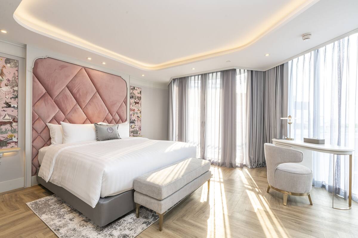 Een moderne slaapkamer met een groot bed, een nachtkastje en een stoel.