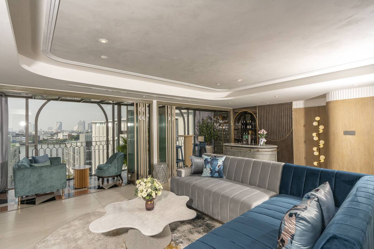 Een moderne woonkamer met een bank, fauteuils en een salontafel.
