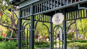 A gazebo with a sign reading "The Pier," benches, and a paved area with a bicycle symbol. - The Salil Hotel Riverside Bangkok (Bangkok)