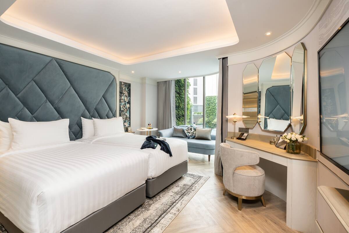 Een moderne hotelkamer met een groot bed, een bureau en een spiegel.