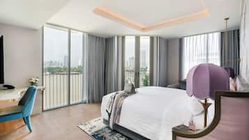 A modern hotel room with a large bed, a desk, and a view of the city.
