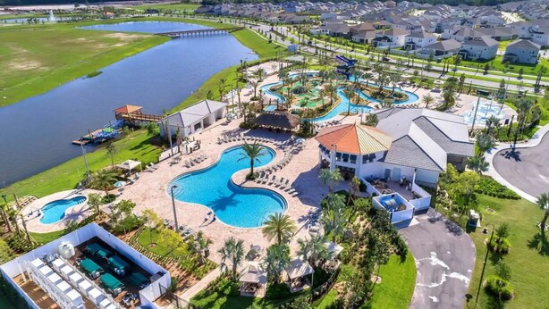 Resort com várias piscinas, parque aquático e um lago grande.