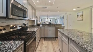 Una cucina moderna con piani in granito, elettrodomestici in acciaio inossidabile e un'isola centrale.