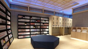 Una biblioteca moderna con estanterías, una zona de estar y casilleros.
