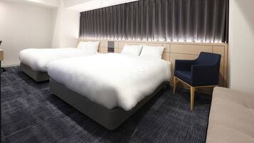 A hotel room with a large bed, two bedside tables, a chair, and a sofa.