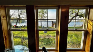 A room with three windows overlooking a lake and grassy area. - Waterfront Cabin w/ Dock Access, Fishing & Kayaks
Beach Retreat - Cabin 3 (South Haven)