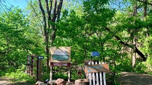 A welcome sign for Lake Augusta Cabins, a trail sign, and a wooden cabin sign. - Waterfront Cabin w/ Dock Access, Fishing & Kayaks
Beach Retreat - Cabin 3 (South Haven)