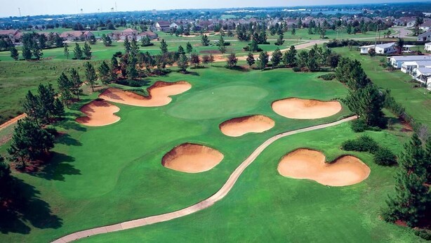An aerial view of a golf course with bunkers and a winding path. - New! 4-bedroom/Pool/Jacuzzi/ PGA Top Golf Course (Haines City)