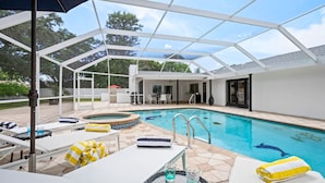 An indoor pool area with a glass ceiling, lounge chairs, and a hot tub. - Luxury Villa with Heated Saltwater Pool & Spa, Mini Golf, BBQ, 5 Mins to Beach (Largo)