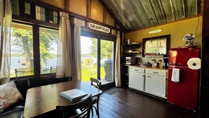 A cozy kitchen with a red refrigerator, wooden cabinets, and a view of the outdoors. - Cozy Lakefront Cabin, Dock, Fire Pit & Sunset Views
Tiny Barn - Cabin 4 (South Haven)