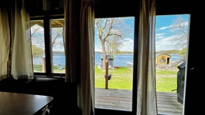 A room with a large window overlooking a lake, a wooden deck, and a small shed. - Cozy Lakefront Cabin, Dock, Fire Pit & Sunset Views
Tiny Barn - Cabin 4 (South Haven)