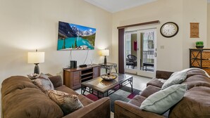 Ein Wohnzimmer mit einer Couch, einem Couchtisch und einem Gemälde von einem Bergsee.