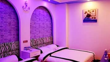 A room with two beds, zebra-patterned headboards, brick walls, and a small shelf with decorative items.