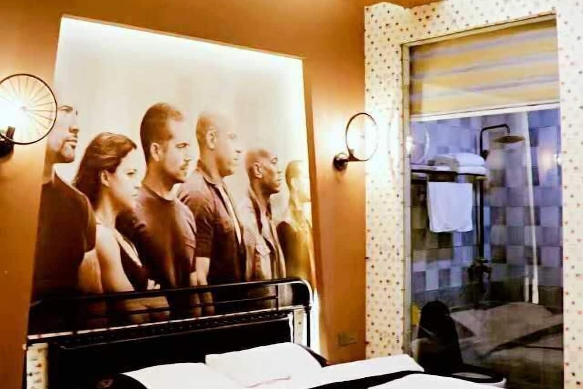Ein Schlafzimmer mit Bett, einem Poster, einem Fenster mit Aussicht und einer an der Wand befestigten Uhr.