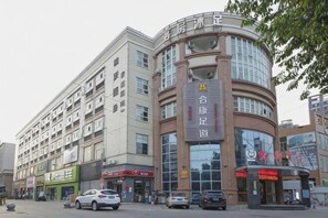 Un edificio de varios pisos con fachada curva, ventanas amplias y señalización que indica que es un hotel.