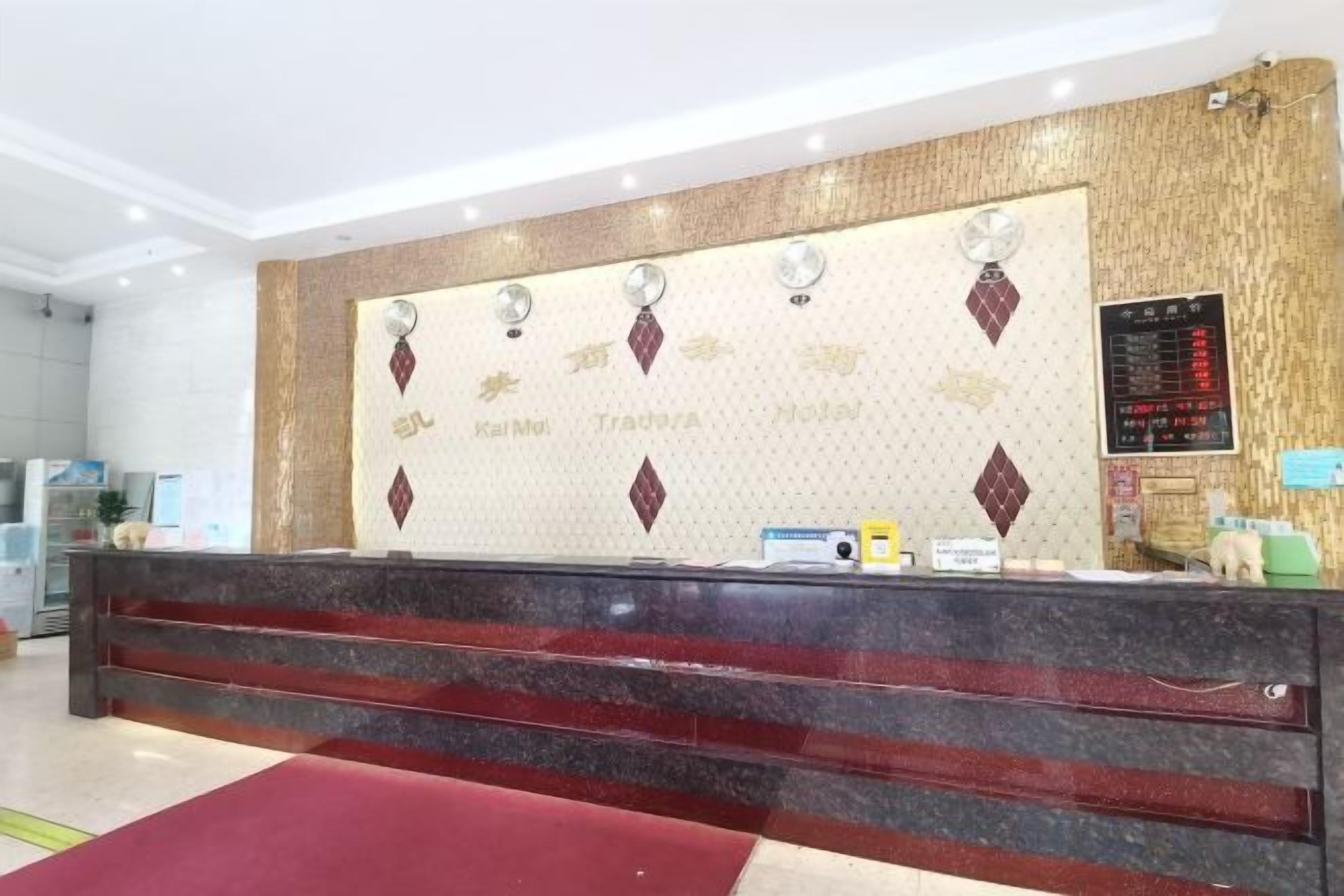 A reception desk with a marble top, a red carpet, and a wall with a decorative pattern and text.