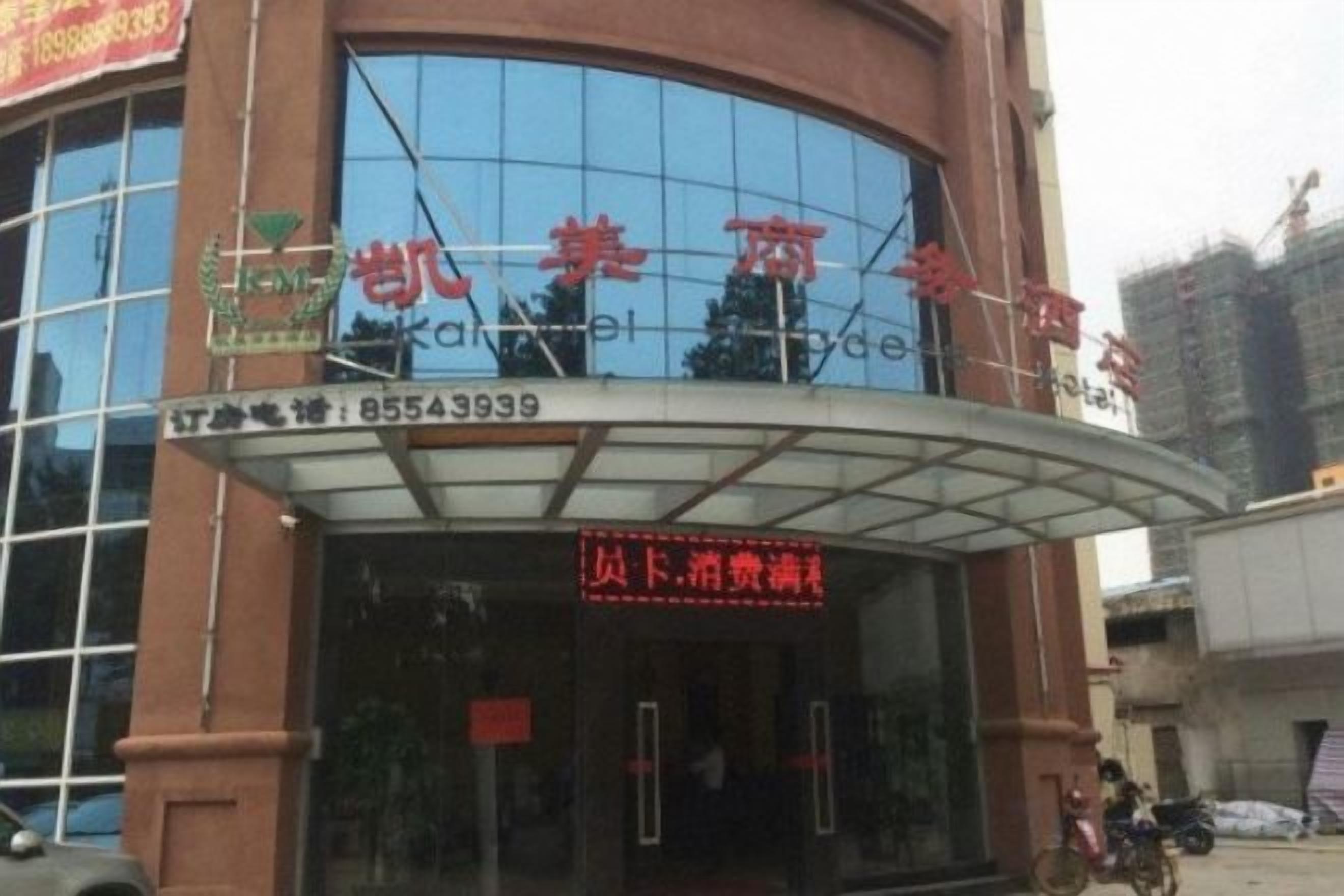 A hotel entrance with a glass facade and a sign indicating a price reduction.